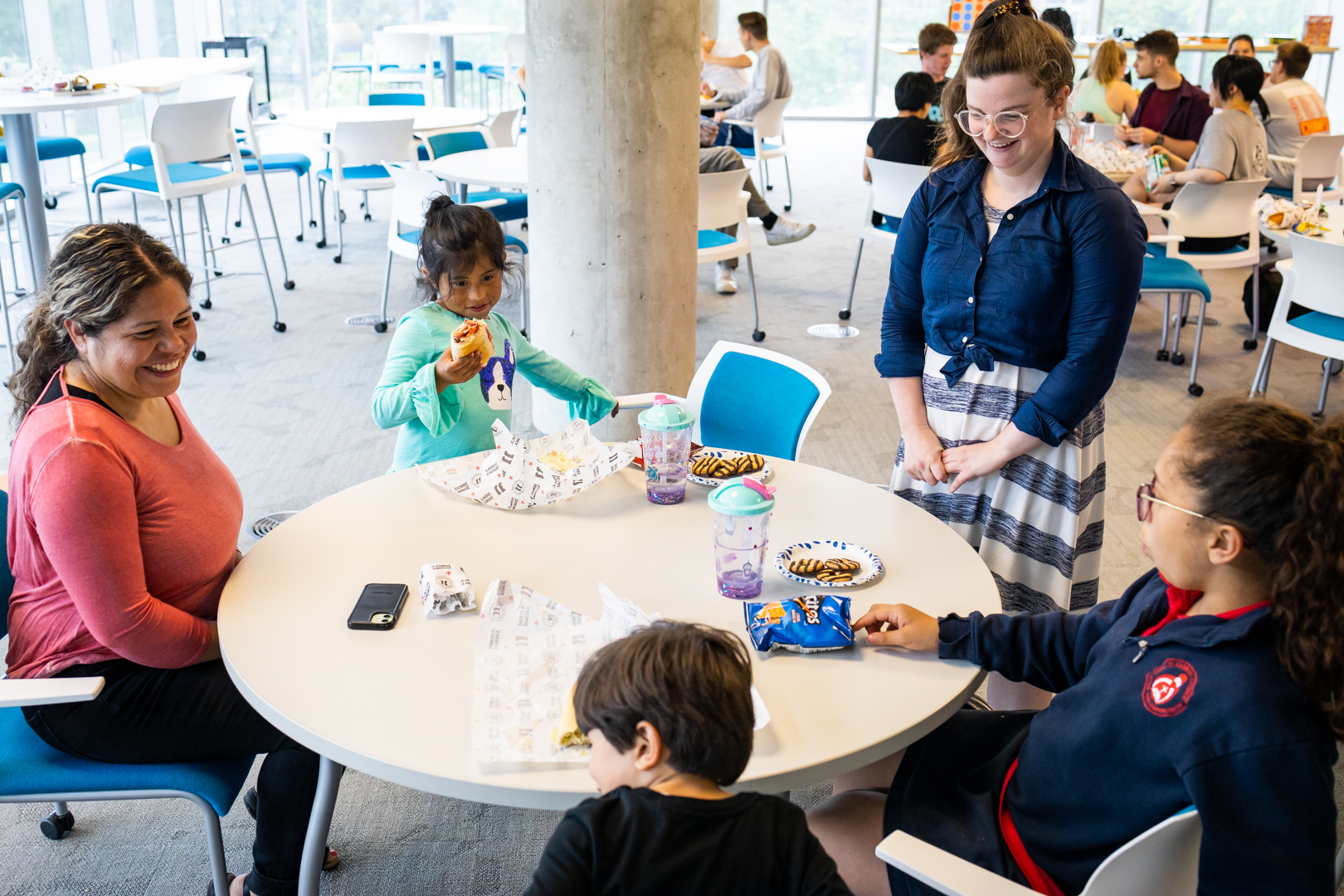 Angelica De La Cruz and her children sitting at a table at the Launch Pad end of year event